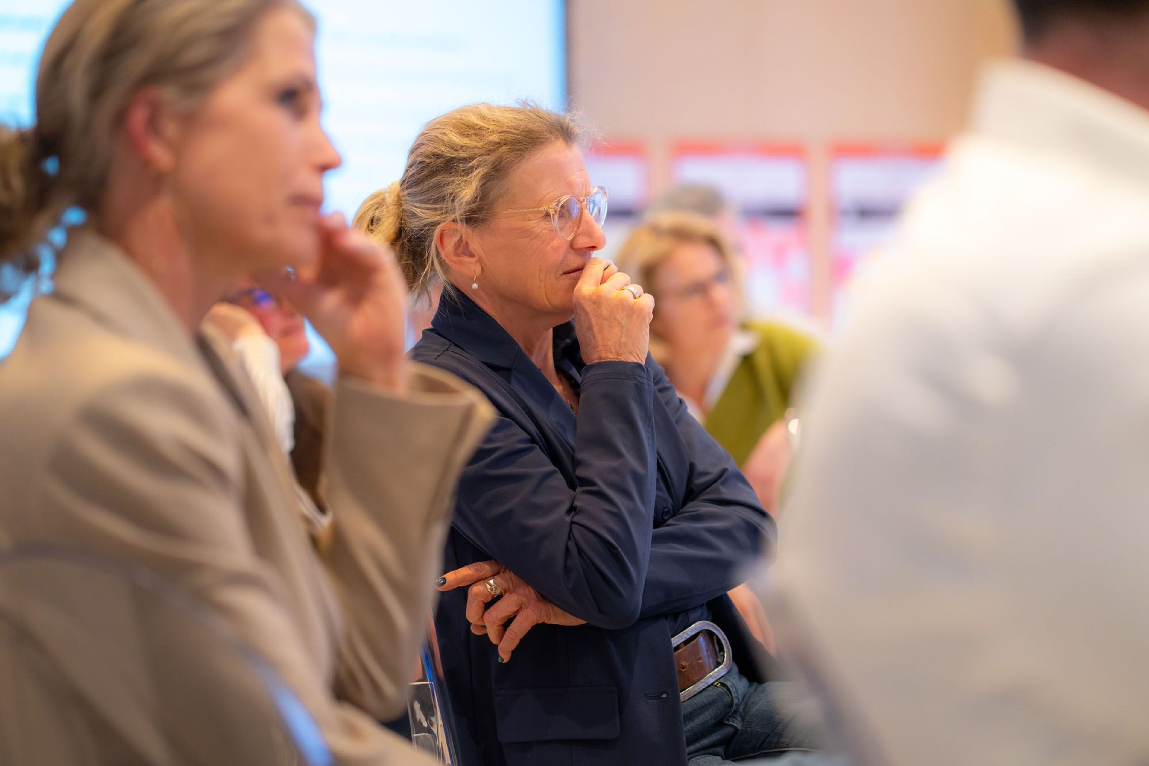 Zittende vrouw in gesprek met anderen.