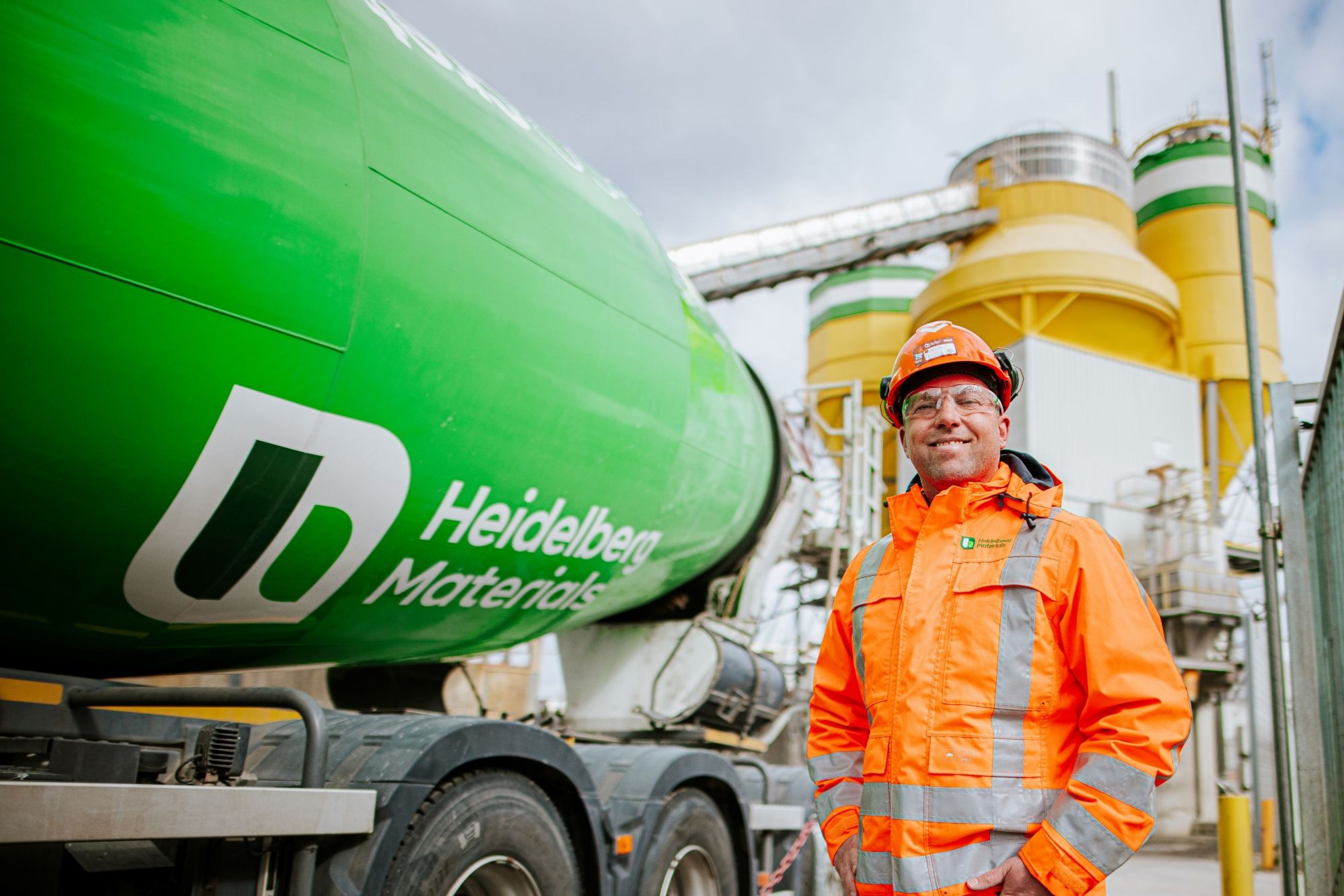 Werknemer met veiligheidsharnassen bij Heidelberg Materials fabriek.