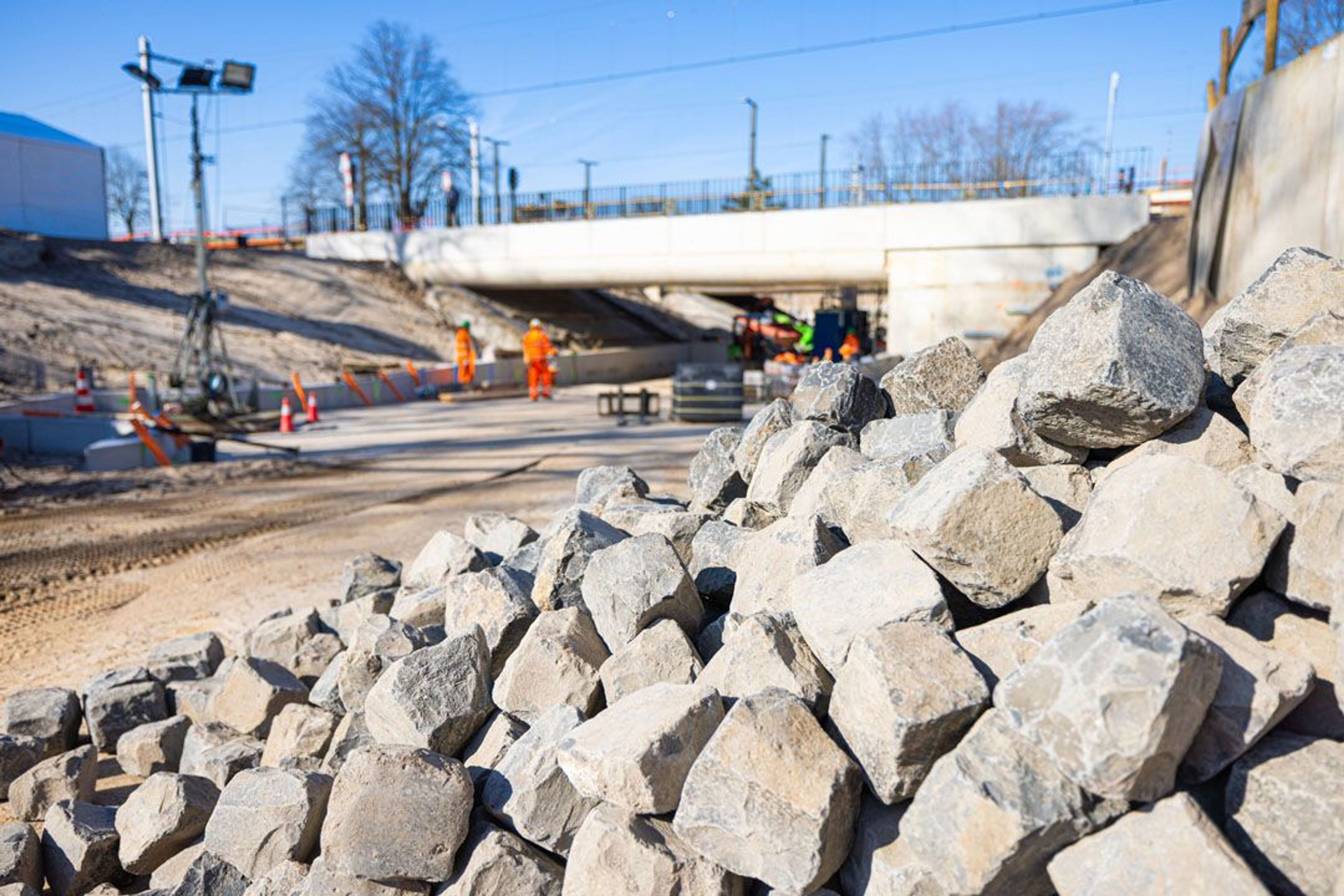 Bouwplaats met stenen en arbeiders in veiligheidskleding