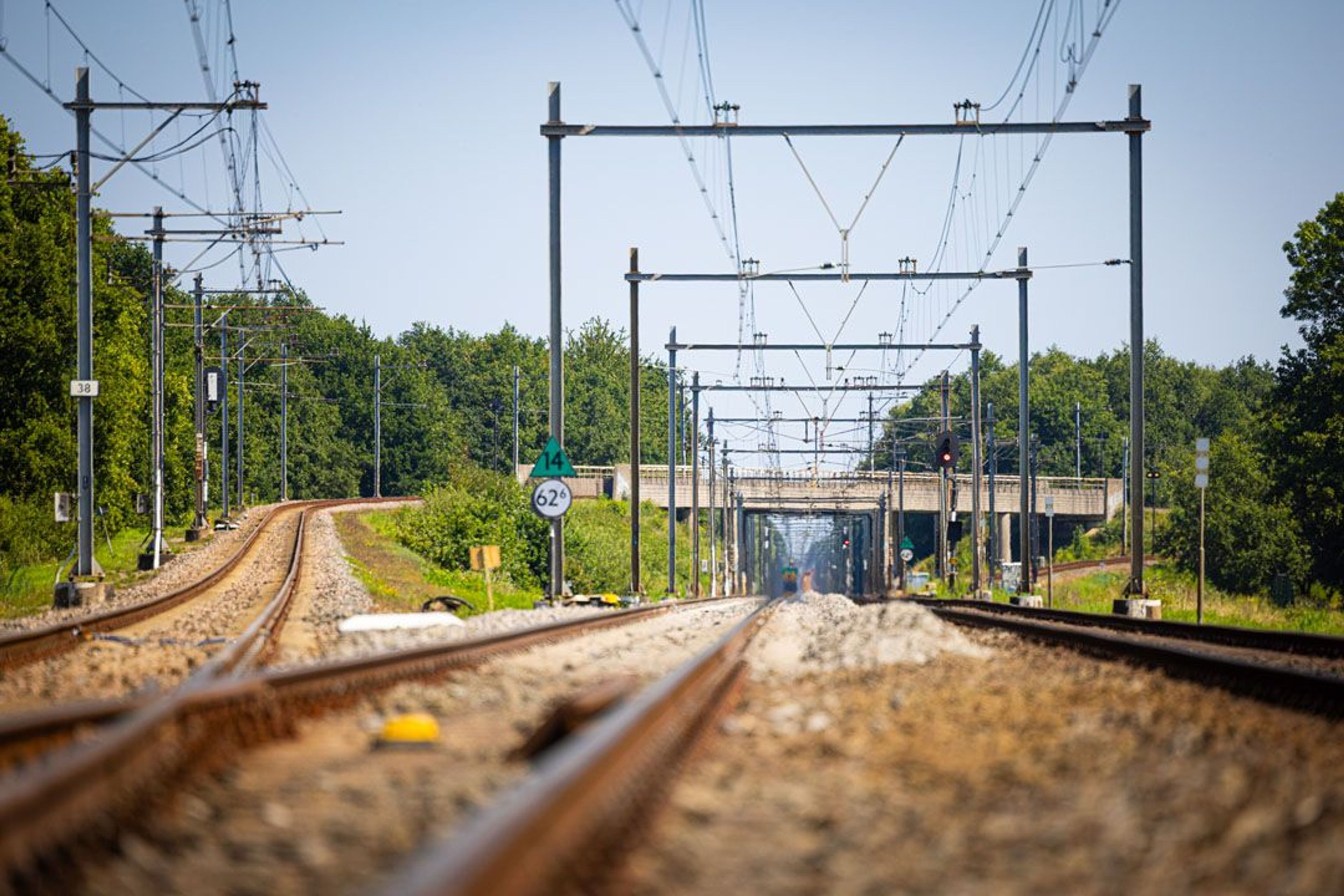 Spoorrails met viaduct en signalen in de verte.