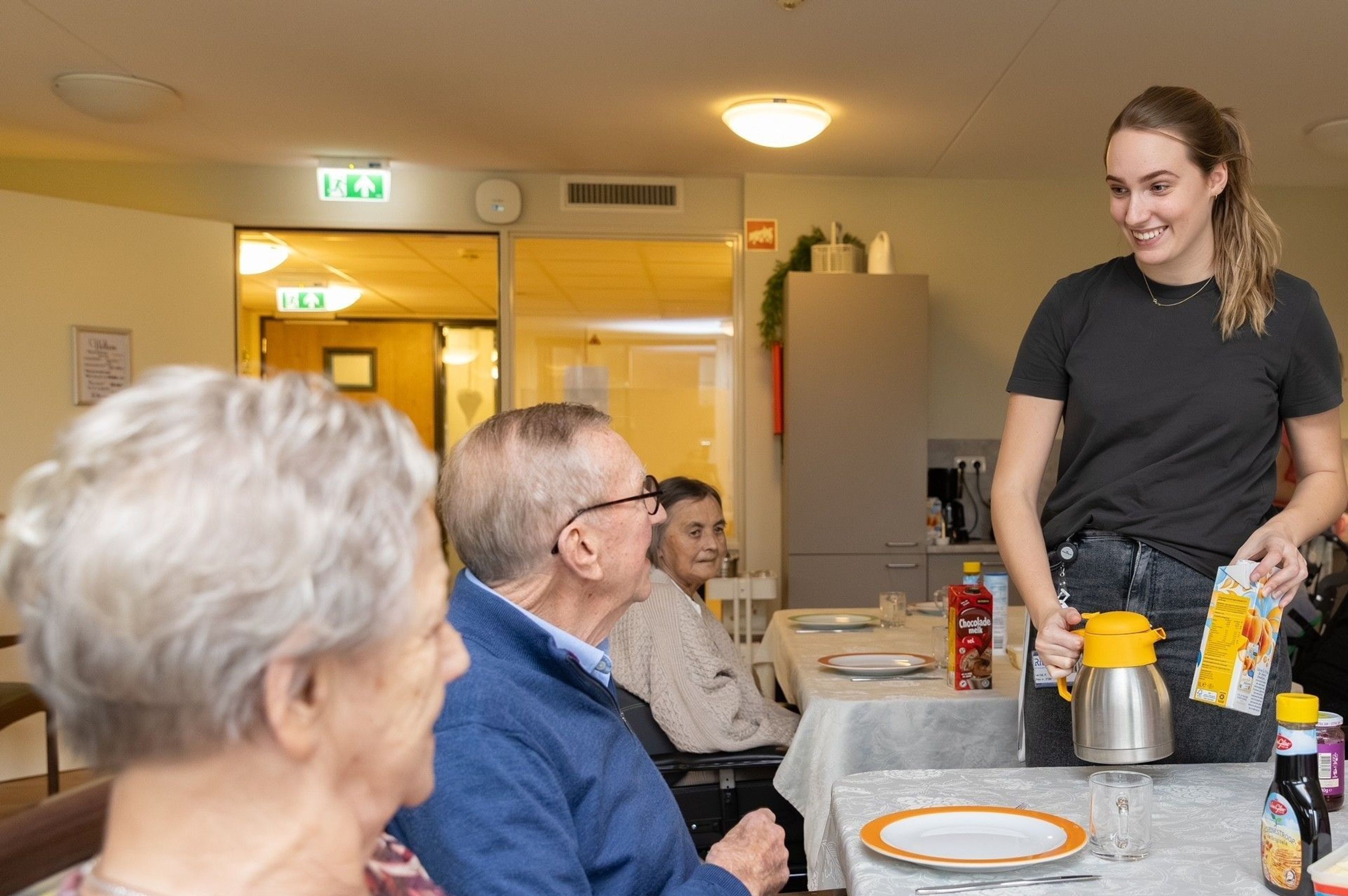 Aged care staff serve drinks to residents.
