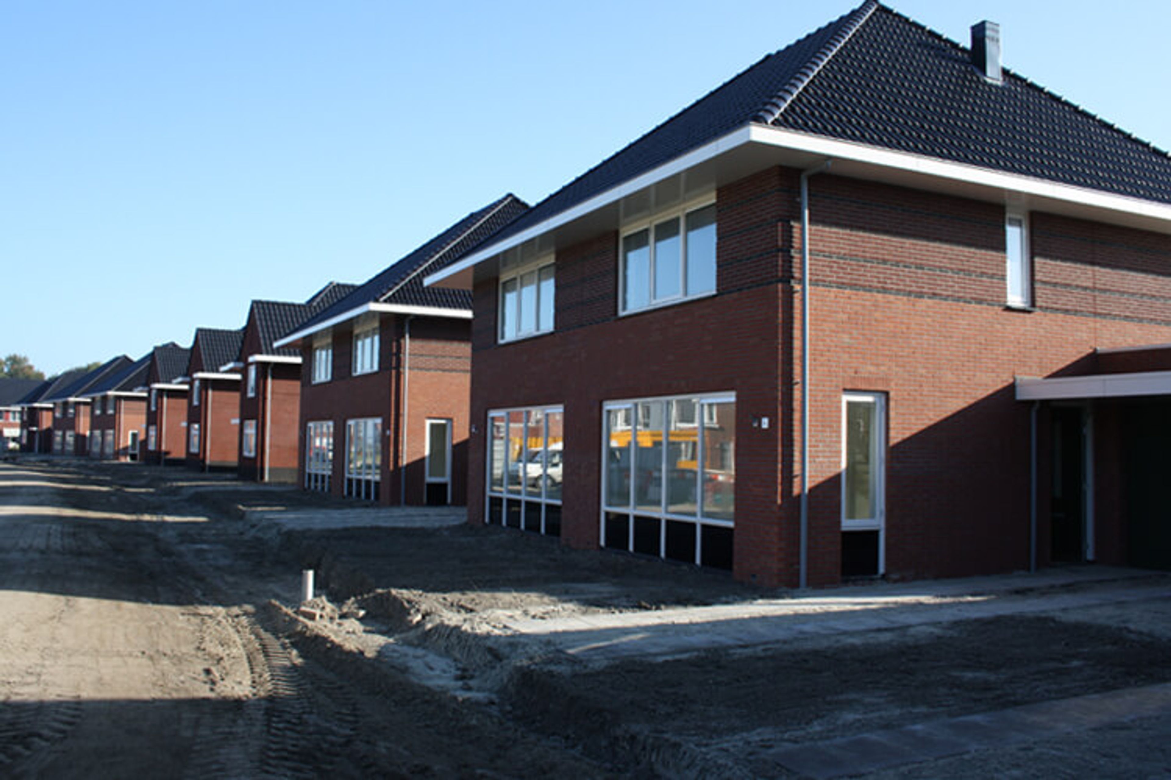 Rij nieuwbouwwoningen in aanbouw met afgewerkt schilderwerk