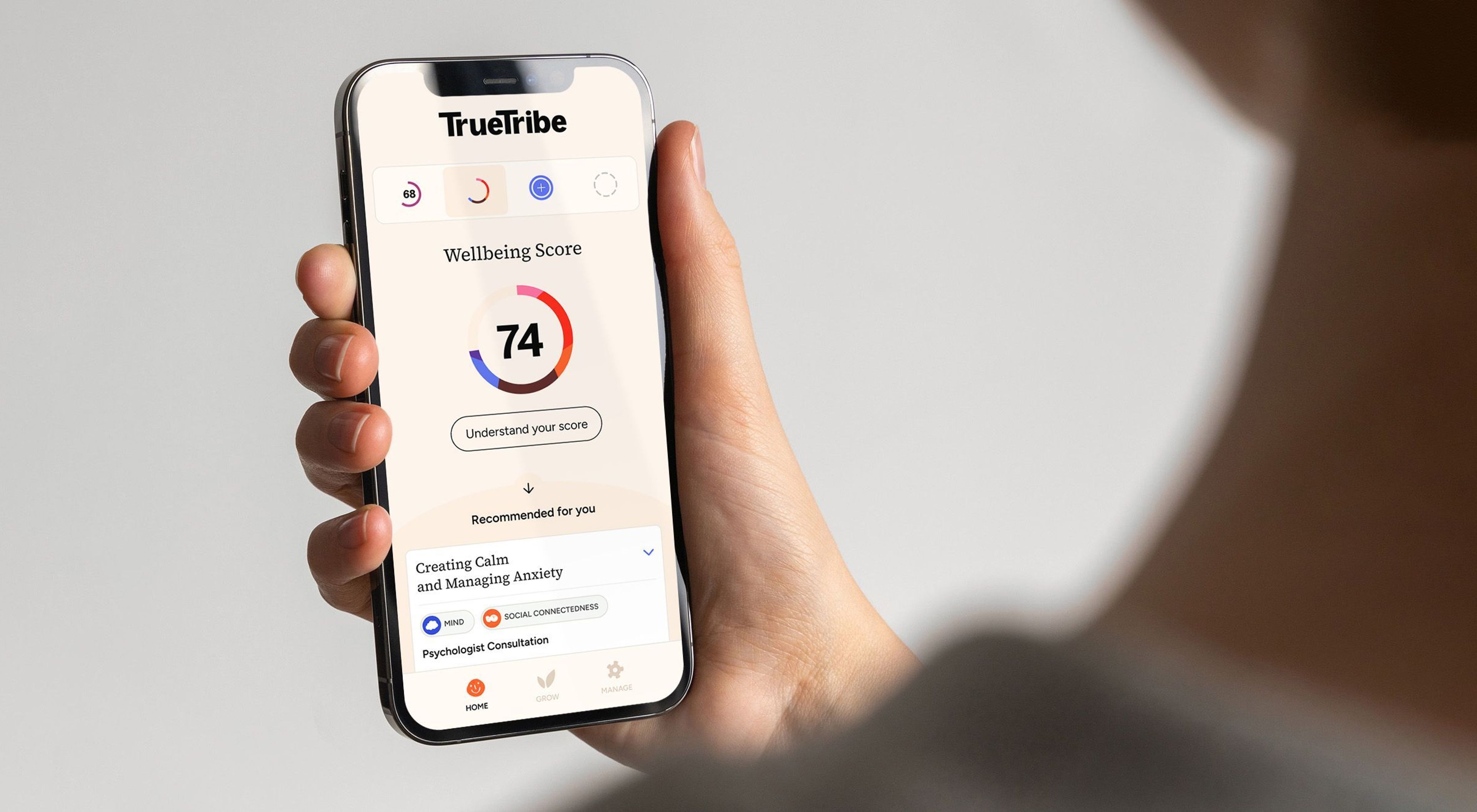 Hand houdt smartphone met TrueTribe-app vast.