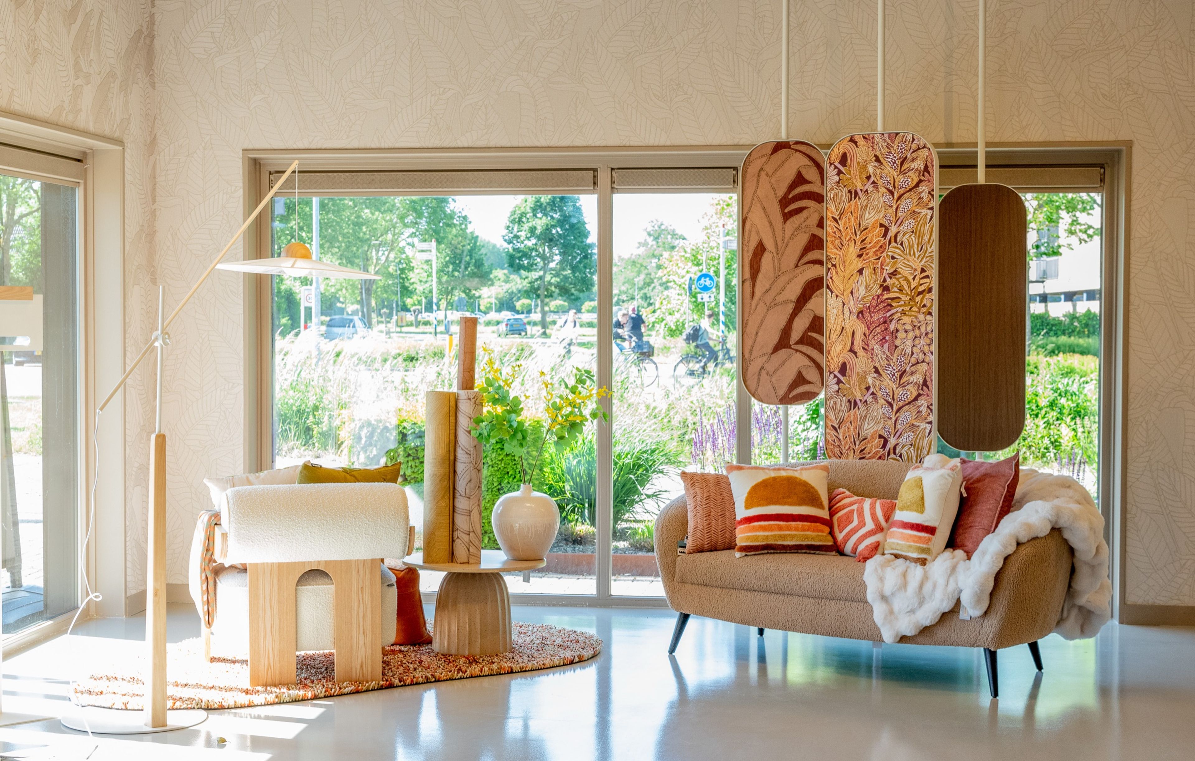 Sfeerhoek met bank, behang en raamdecoratie in het Decorette woonatelier