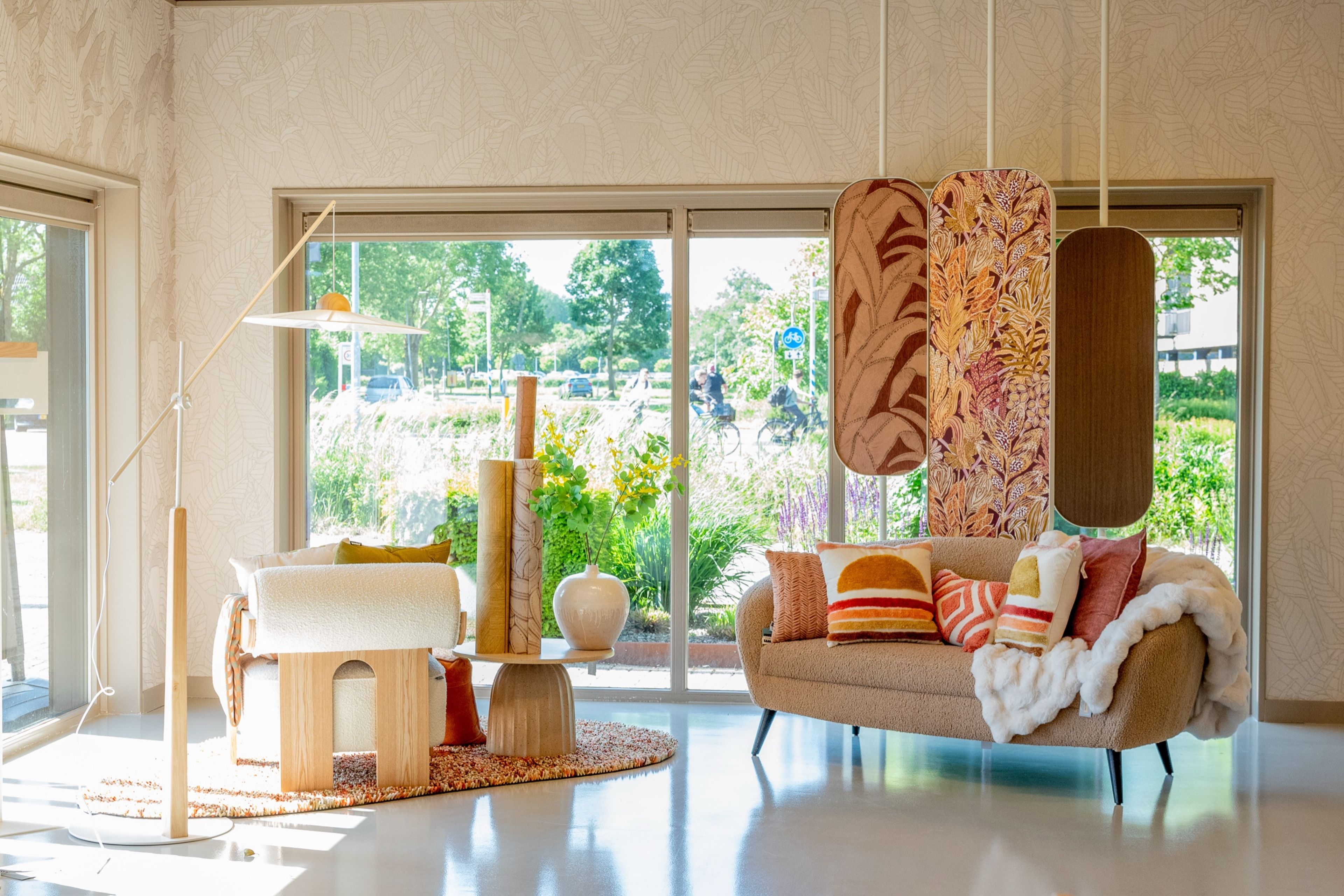 Sfeerhoek met bank, behang en raamdecoratie in het Decorette woonatelier