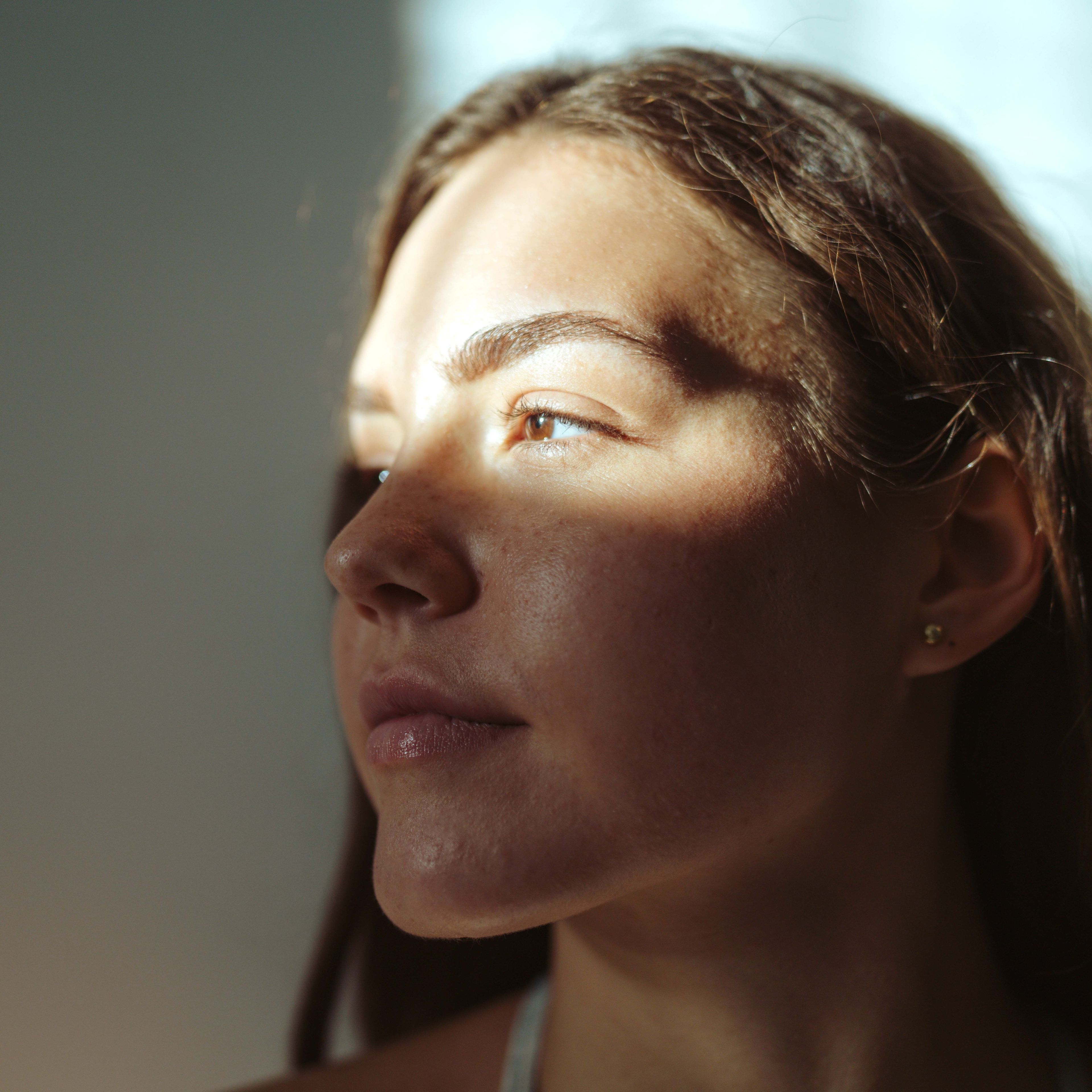 Jonge vrouw met zonlicht op haar gezicht