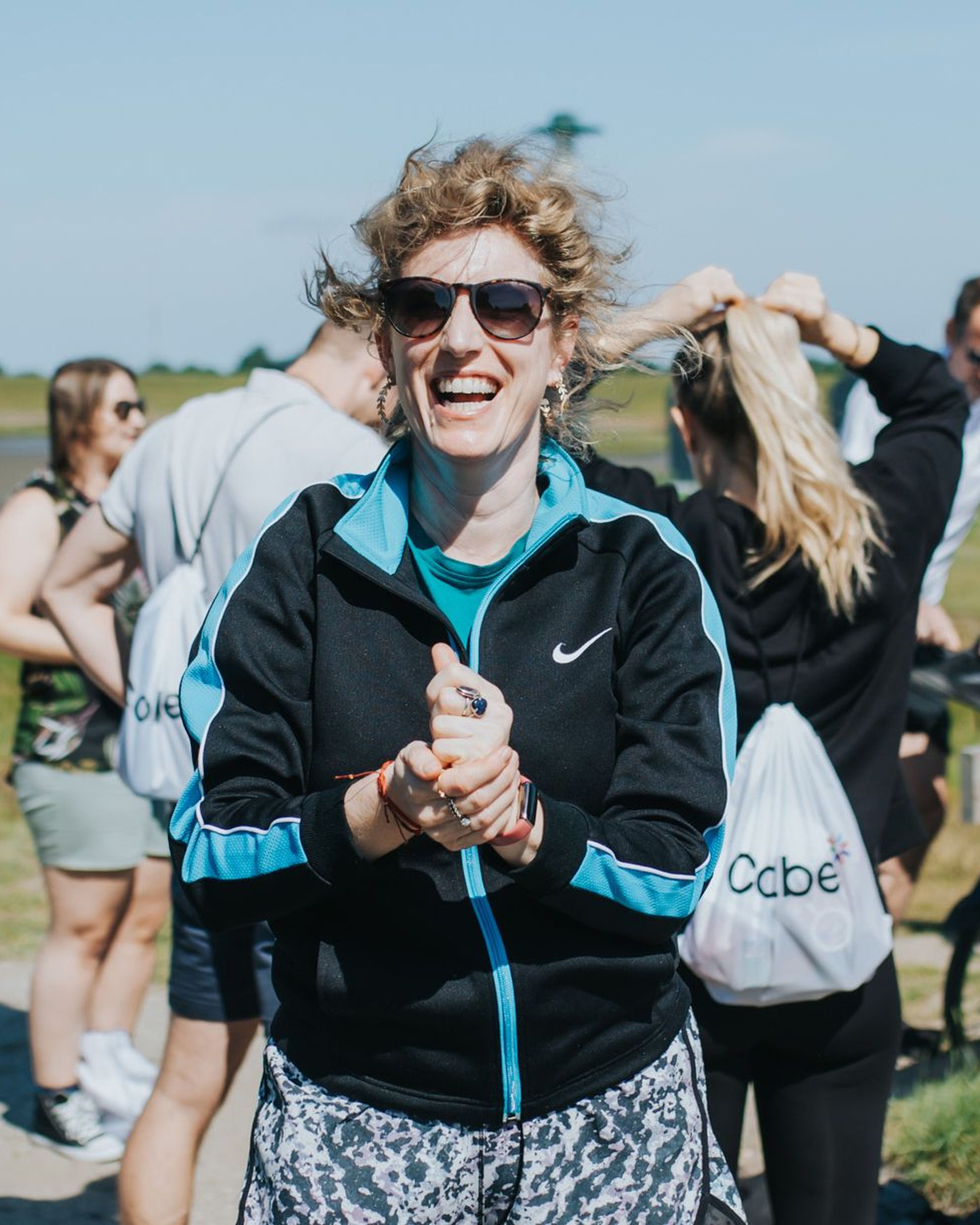 Vrolijke vrouw in sportkleding, lachend op het veld.