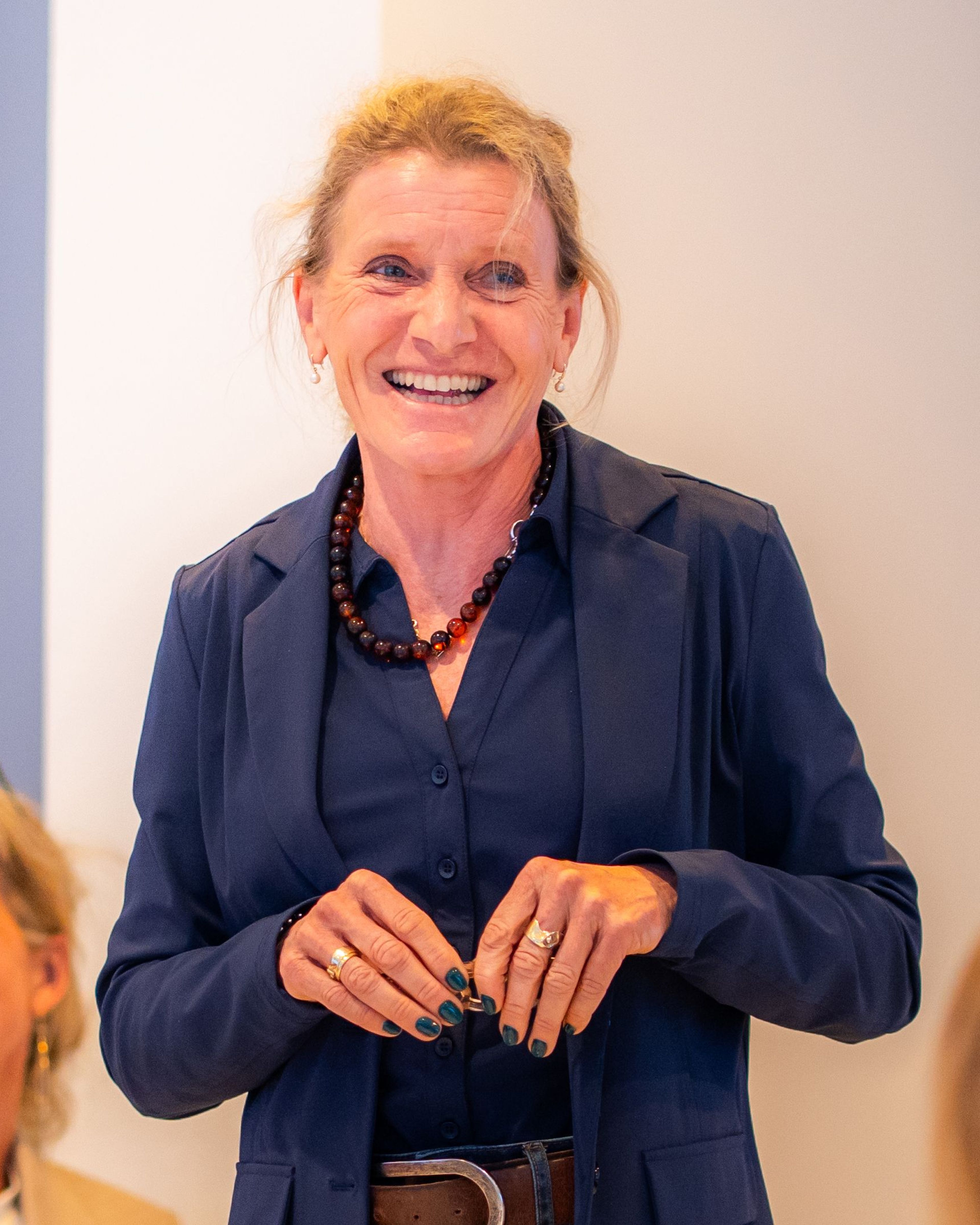 Vrouw met een blijde lach staat te spreken.