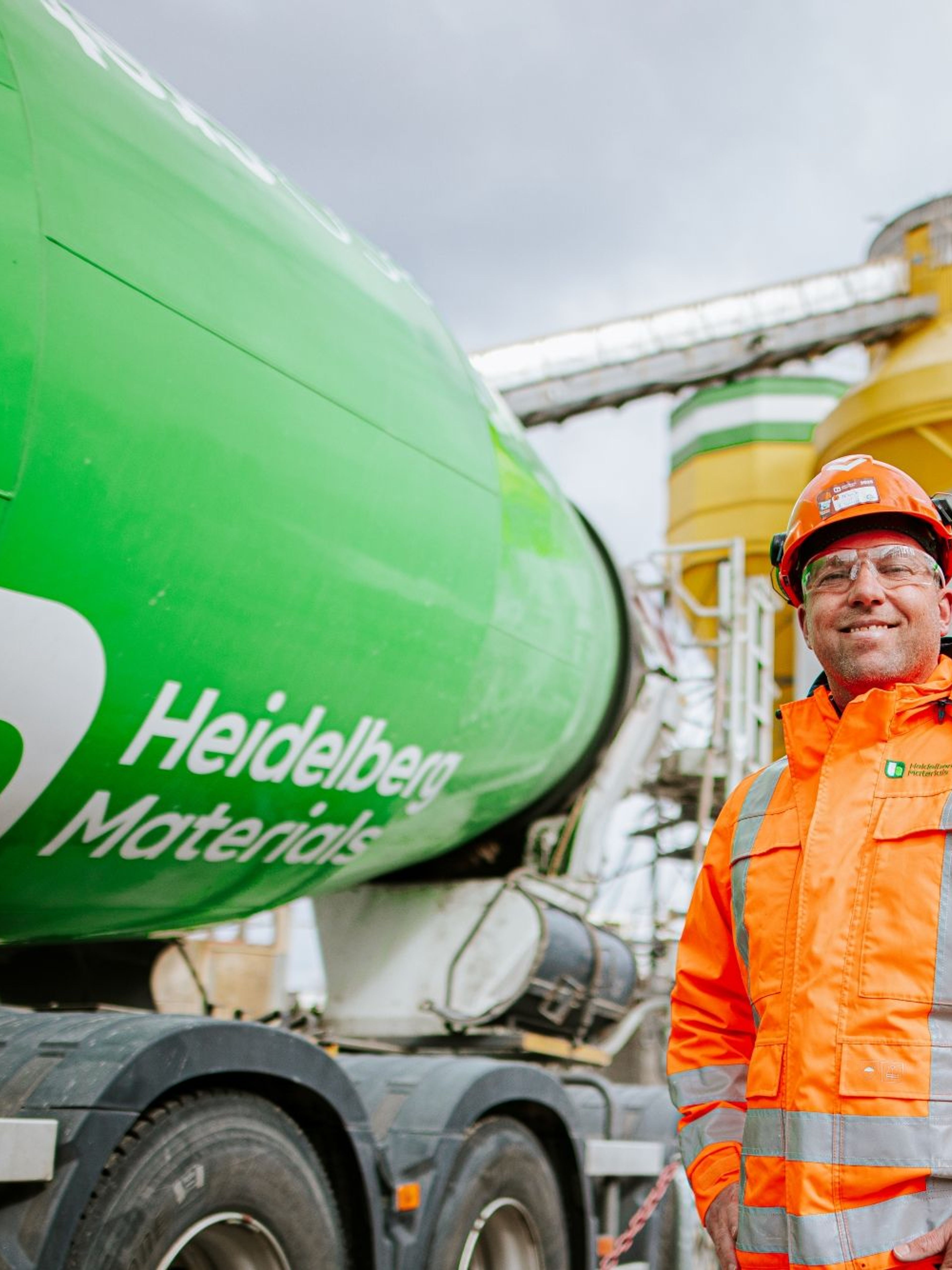 Werknemer met veiligheidsharnassen bij Heidelberg Materials fabriek.