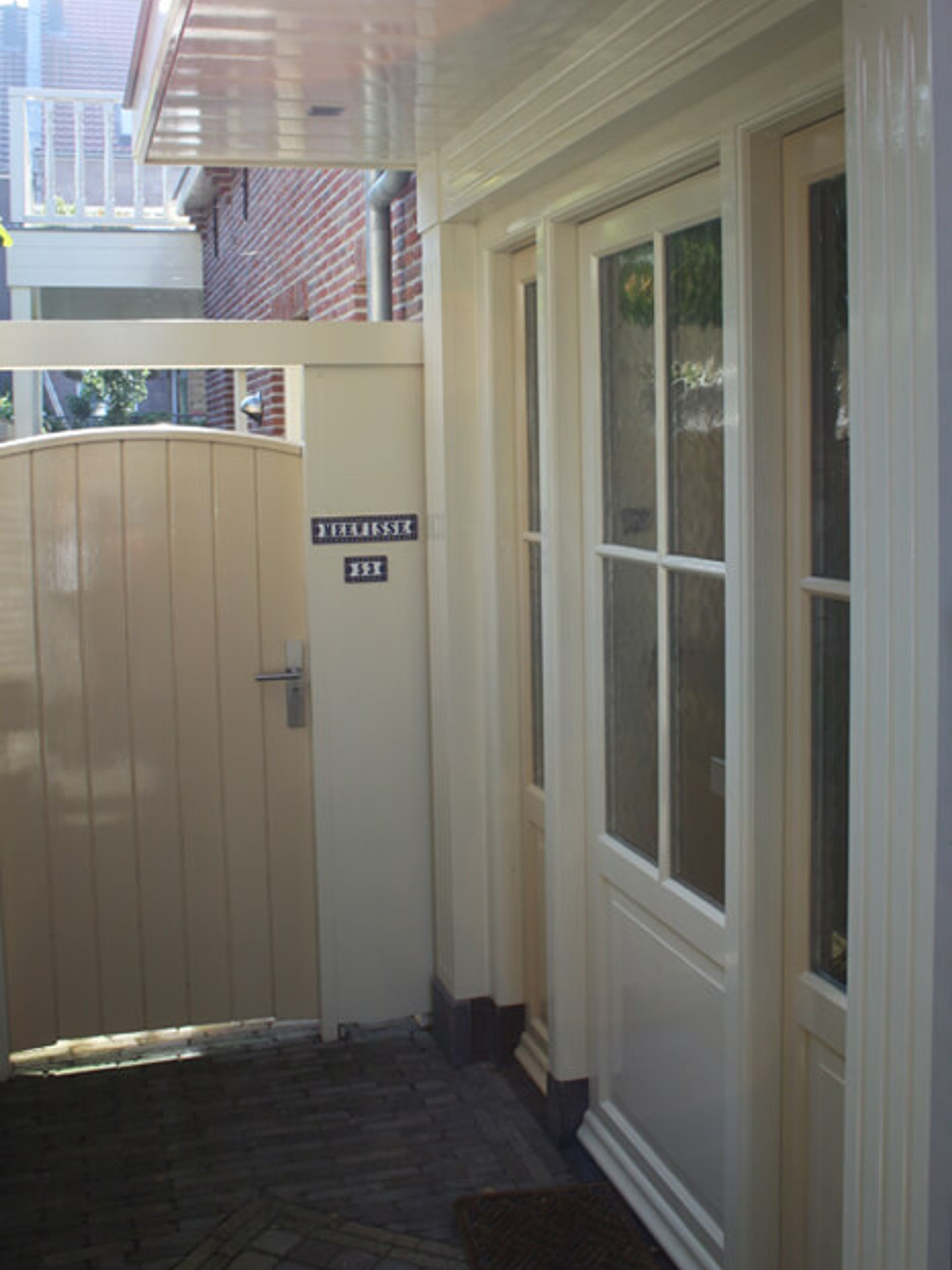 Geschilderde voordeur en tuinpoort van een woning