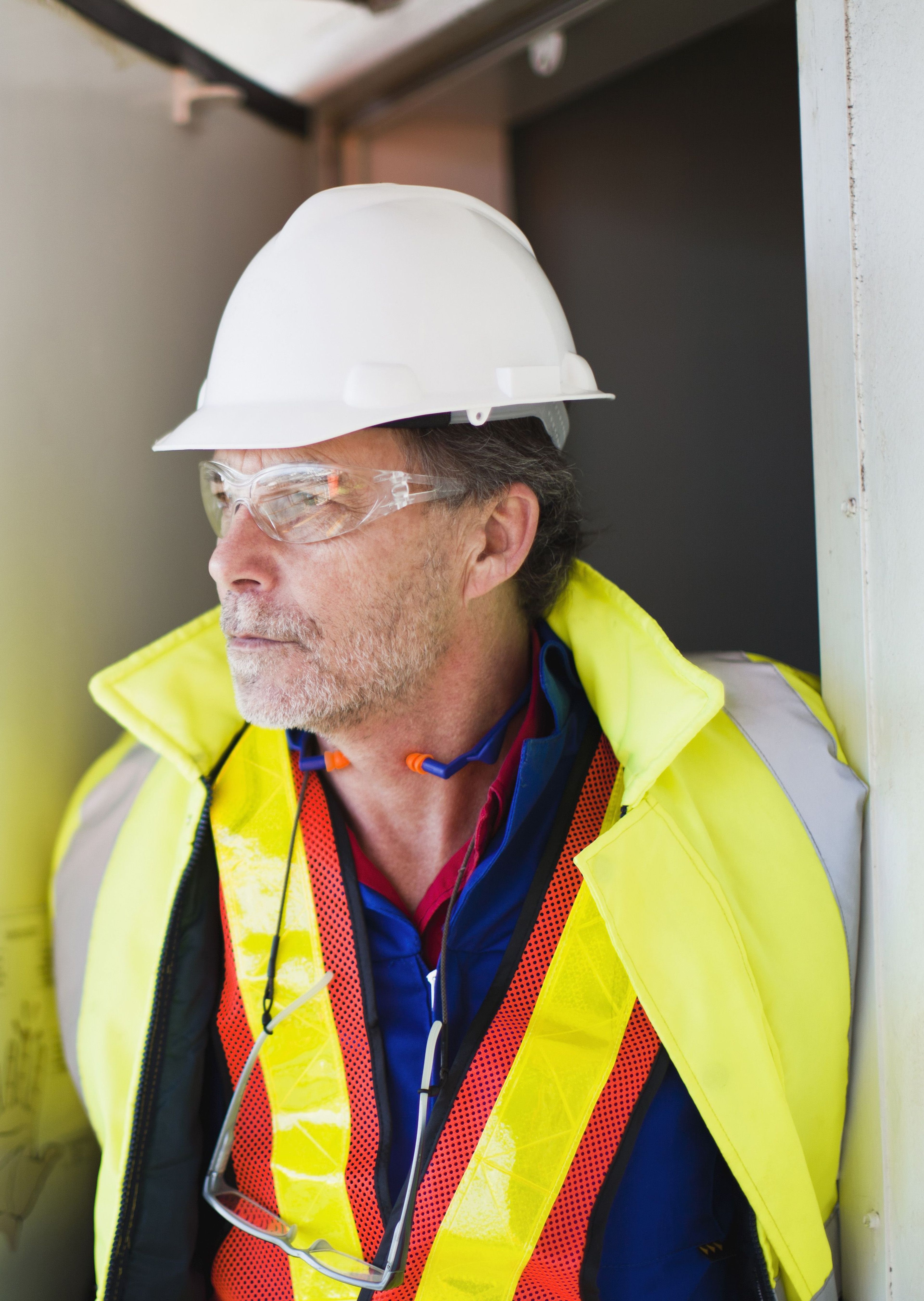 Man in veiligheidskleding met helm en bril.